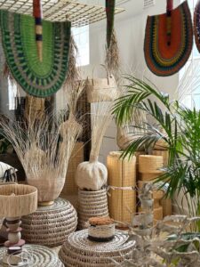 African baskets at Design Afrika, arranged in a pleasing manner, with houseplants and fans hanging from the ceiling.